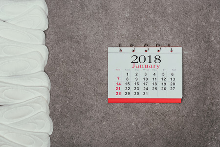 top view of arranged menstrual pads and calendar