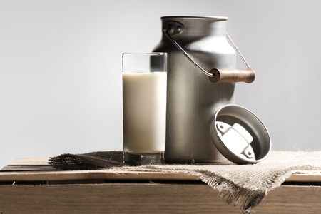 fresh milk in glass and can on greyの写真素材