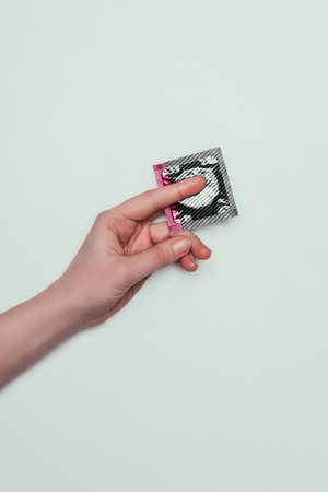 cropped shot of woman with condom in handの写真素材