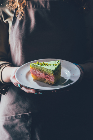 woman holding piece of homemade cake on plate in handsの写真素材