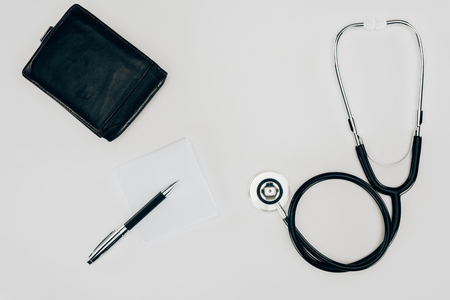 medical stethoscope, wallet and pen on white surfaceの写真素材