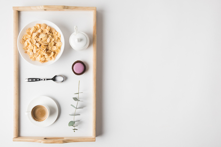 top view of breakfast with cork flakes in bowl and cup of coffee on trayの写真素材