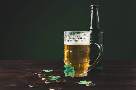 glass of beer with shamrock and golden coins on table, st patricks day conceptの写真素材