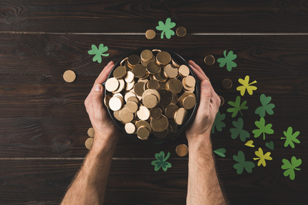 cropped image of man holding pot with golden coins, st patricks day conceptの写真素材