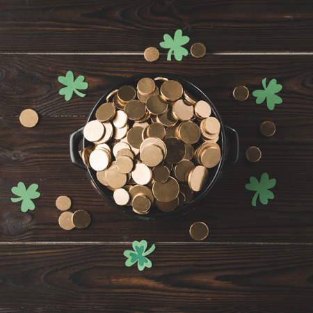 top view of pot with golden coins and shamrock on wooden table, st patricks day conceptの写真素材