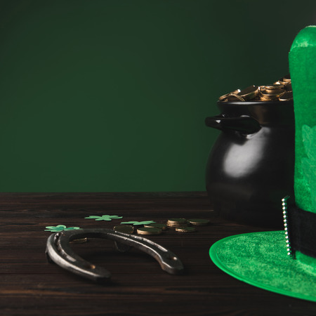 golden coins, horseshoe and green hat on wooden table, st patricks day conceptの写真素材