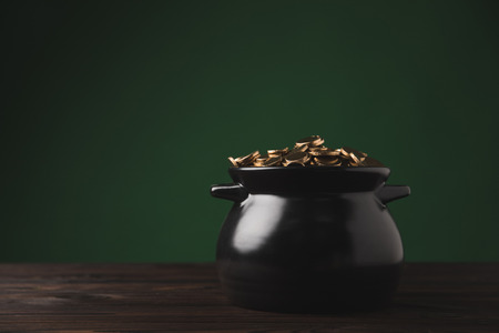 pot of golden coins on wooden table, st patricks day conceptの写真素材