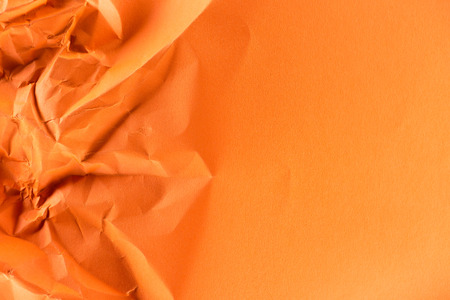 close-up shot of orange crumpled paper for backgroundの写真素材