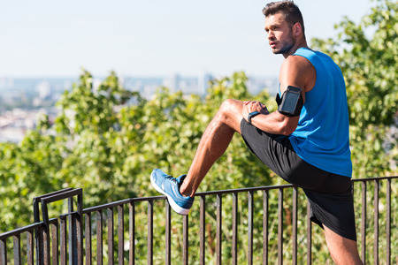 sportsman stretching in park