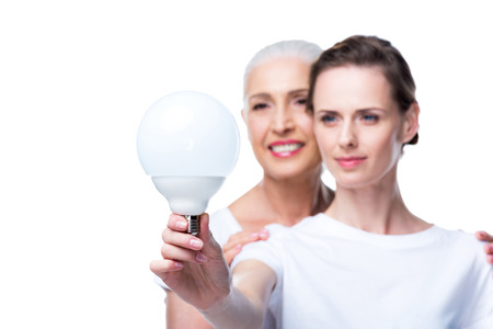 adult daughter and mother with light bulbの写真素材