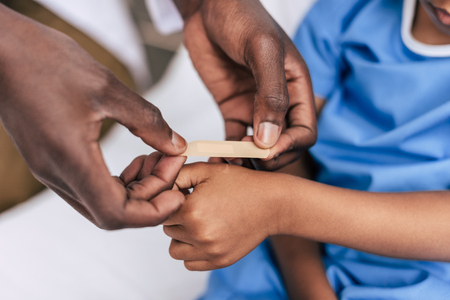 african american doctor putting adhesive plasterの写真素材