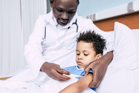 african american doctor measuring patients temperatureの写真素材