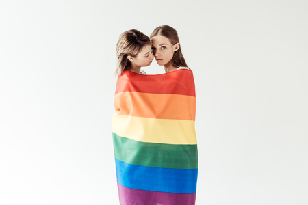 Lesbian couple wrapped in rainbow flagの写真素材