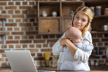 businesswoman with baby in handsの写真素材