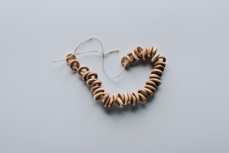 top view of sweet tasty bagels on rope isolated on grey
