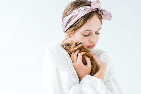 girl holding adorable furry bunny isolated on whiteの写真素材