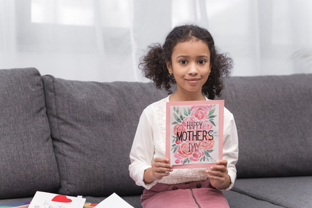 kid showing greeting card for mothers dayの写真素材