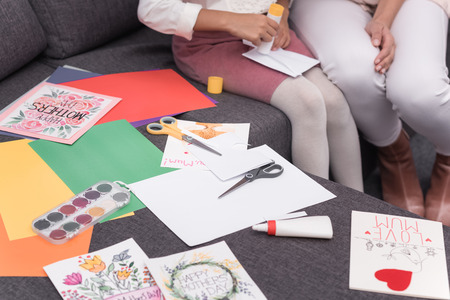 african american mother helping daughter making greeting cards on mothers dayの写真素材