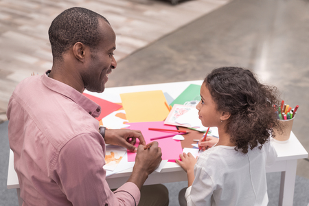 father and daughter making greeting card on mothers day and looking at each otherの写真素材
