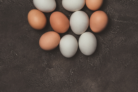 top view of white and brown chicken eggs on table の写真素材