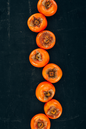 top view of row of persimmons on blackの写真素材
