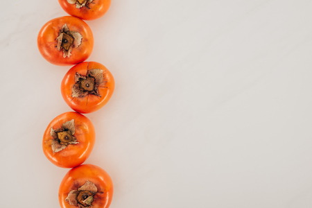 top view of persimmons in row isolated on whiteの写真素材
