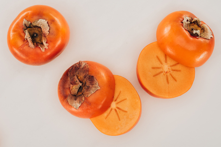 top view of ripe cut persimmons isolated on whiteの写真素材