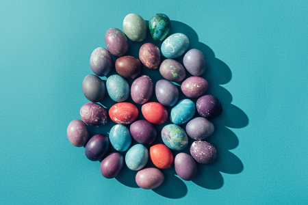 food composition with easter eggs in shape of egg, on blue