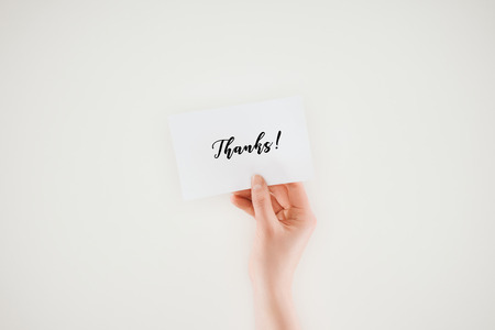 cropped shot of woman holding paper with thanks lettering isolated on whiteの写真素材