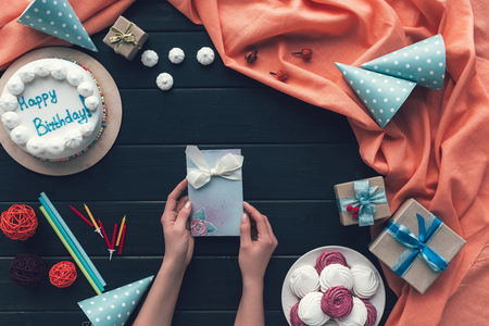 Cropped image of woman holding postcard above the tableの写真素材