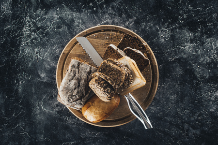 top view of fresh bread and knife on wooden cutting boardの写真素材