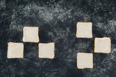 top view of fresh healthy toasts with butter on black slate boardの写真素材