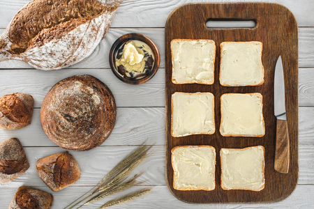 top view of fresh toasts with butter and multigrain bread on wooden tableの写真素材