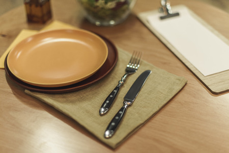 selective focus of cutlery, empty plates and napkins on wooden tabletopの写真素材