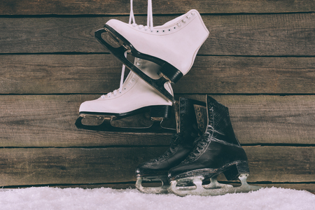 pairs of white and black skates near wooden wallの写真素材
