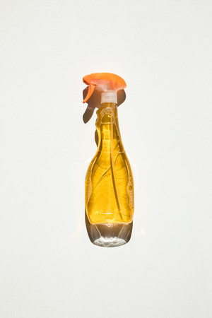 top view of spray bottle with yellow cleaning fluid isolated on whiteの写真素材