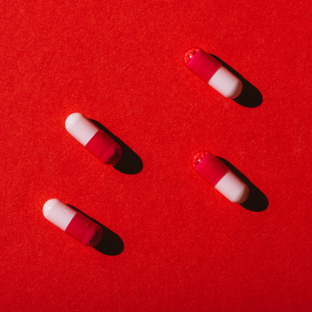 top view of medical capsules with shadows on redの写真素材