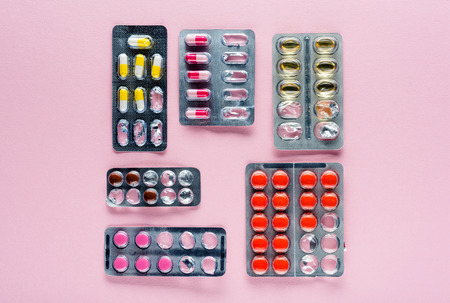 top view of various medicine  in blister packs on pink の写真素材