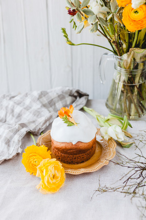 Easter cake on plate and spring flowers on table