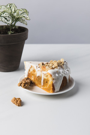 Cake on plate and walnuts with potted plantの写真素材