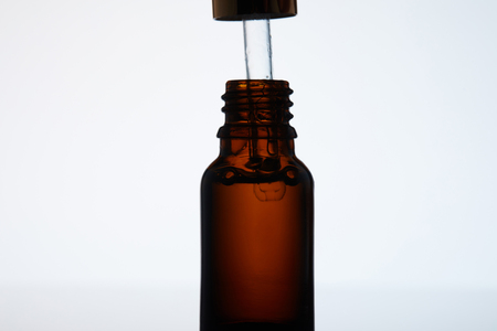 close-up shot of bottle of aromatic oil with pipette on whiteの写真素材