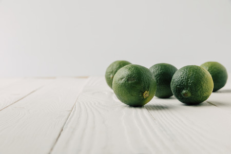 Ripe limes on white wooden backgroundの写真素材
