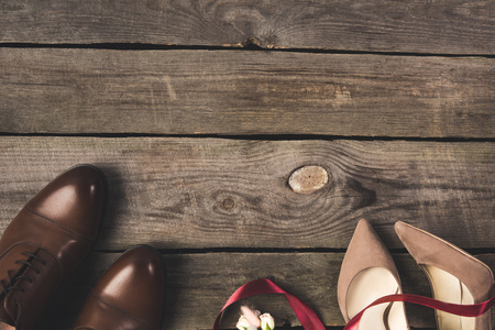 top view of beautiful bridal shoes and corsage on wooden tabletopの写真素材