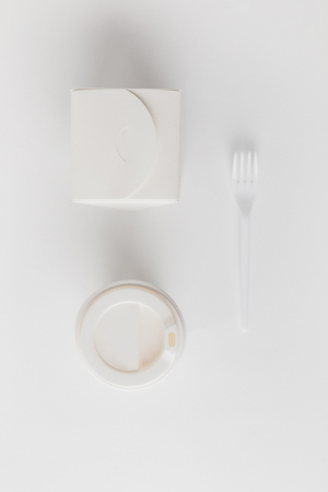 top view of coffee to go, noodles box and fork on whiteの写真素材