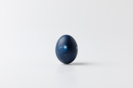 one blue painted easter egg on whiteの写真素材