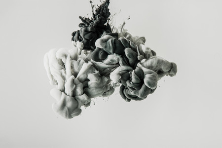 close up view of mixing of light gray and black paints splashes in water isolated on grayの写真素材