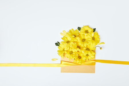 Yellow chrysanthemum flowers in envelope with ribbon isolated on whiteの写真素材