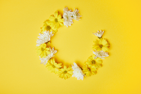 Floral wreath of yellow and white chrysanthemums isolated on yellowの写真素材