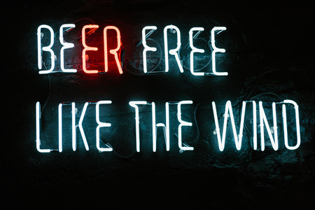 beer free like the wind neon inscription on dark wall in barの写真素材