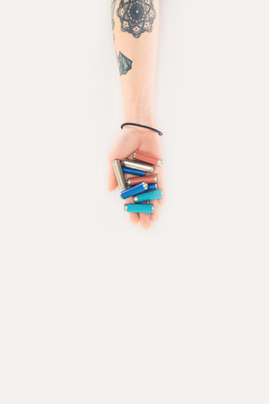 cropped shot of woman holding batteries in hand isolated on white